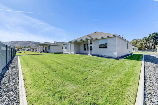 rear view of property with fence, crawl space, and a yard