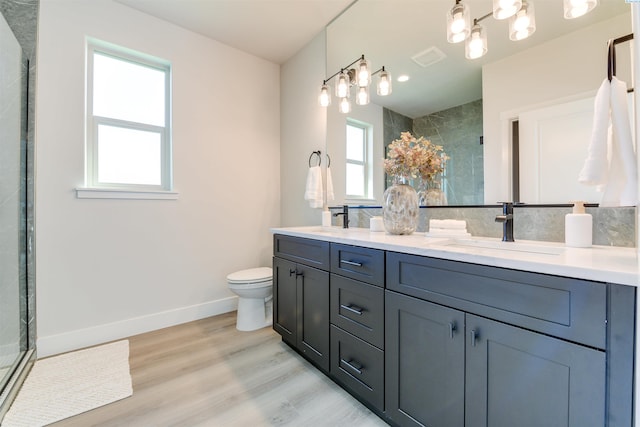 bathroom featuring a stall shower, baseboards, wood finished floors, and a sink