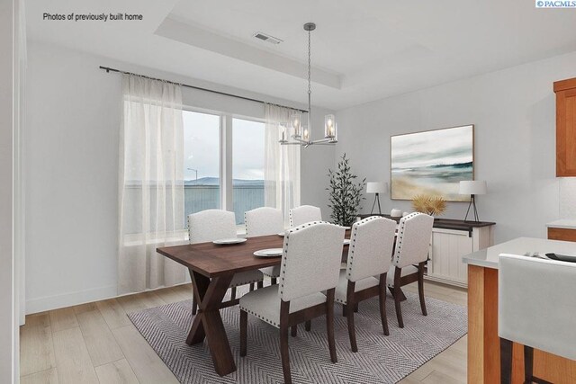 2781 Avrio Ave, Richland, WA 99354 - dining area featuring a chandelier, light wood-style flooring, and a raised ceiling