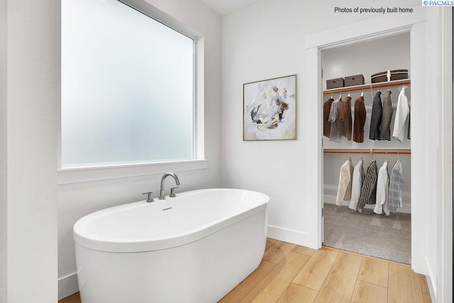 2781 Avrio Ave, Richland, WA 99354 - full bathroom featuring wood finished floors, a soaking tub, a walk in closet, and baseboards