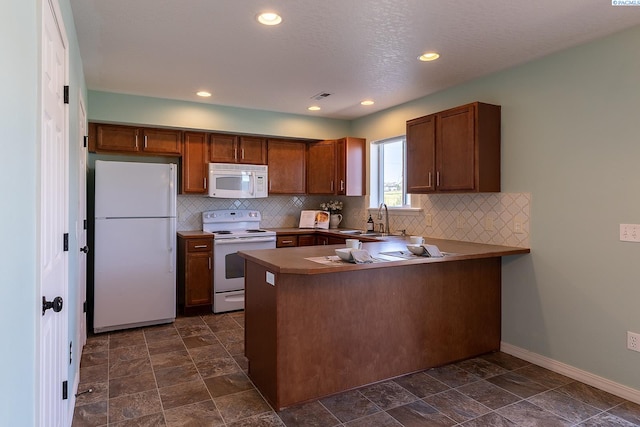 kitchen with decorative backsplash, a peninsula, white appliances, baseboards, and a sink
