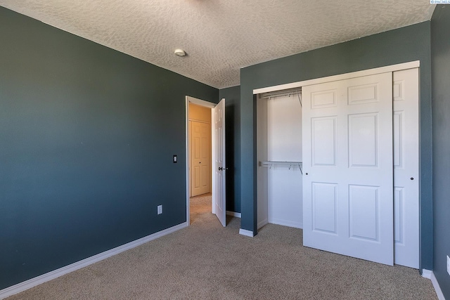 unfurnished bedroom with a closet, carpet flooring, and a textured ceiling