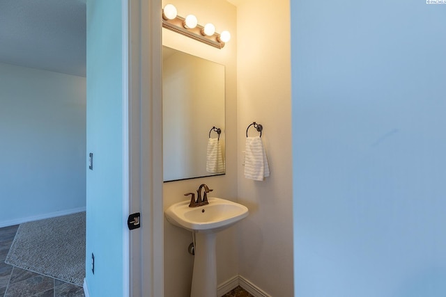 bathroom featuring baseboards and a sink