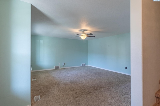 spare room featuring visible vents, a ceiling fan, carpet, and baseboards