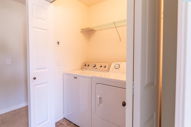 washroom featuring laundry area, baseboards, and washing machine and clothes dryer