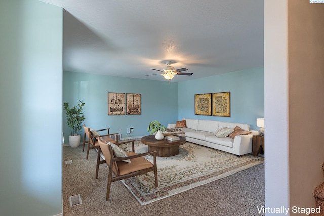 carpeted living area with visible vents, baseboards, and ceiling fan