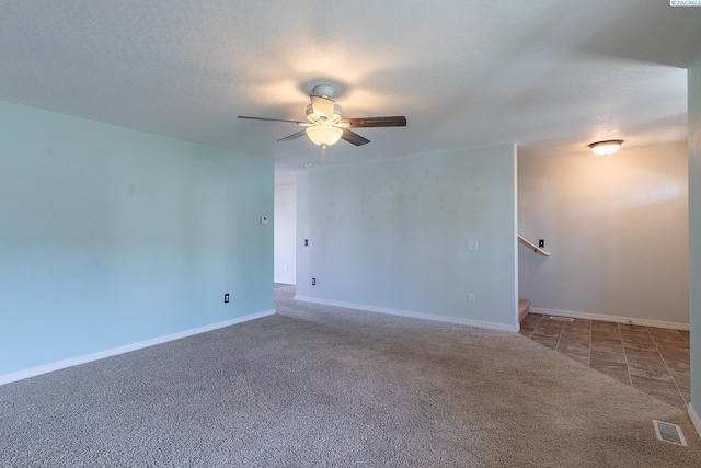 empty room featuring baseboards, carpet, a ceiling fan, and visible vents