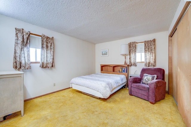 bedroom featuring a textured ceiling, a closet, carpet, and baseboards