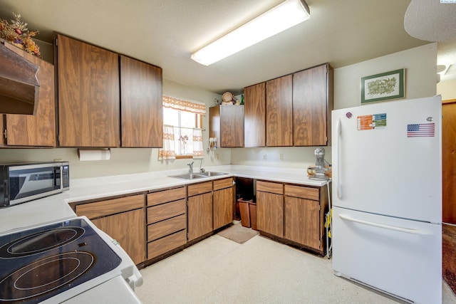 kitchen with white appliances, brown cabinets, light countertops, light floors, and a sink