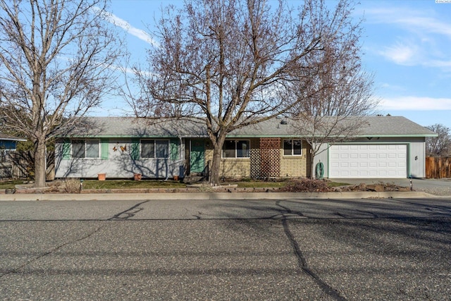 ranch-style home featuring concrete driveway, brick siding, and an attached garage