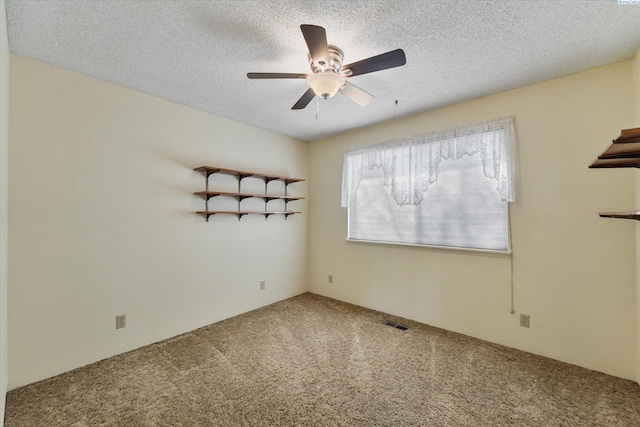 carpeted empty room featuring a ceiling fan, visible vents, and a textured ceiling