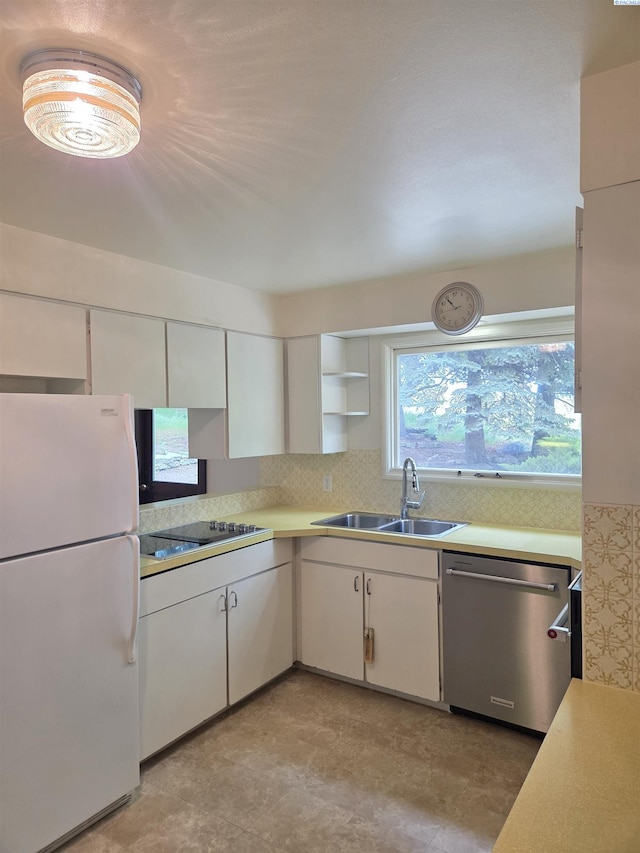 6302 Sand Rd, Pullman, WA 99163 - kitchen featuring freestanding refrigerator, stainless steel dishwasher, a sink, light countertops, and white cabinets