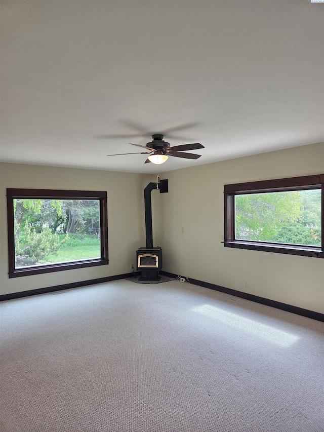 6302 Sand Rd, Pullman, WA 99163 - carpeted spare room featuring a wood stove, healthy amount of natural light, and baseboards