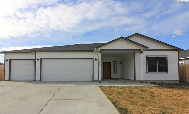 single story home featuring a front yard, an attached garage, fence, concrete driveway, and roof with shingles