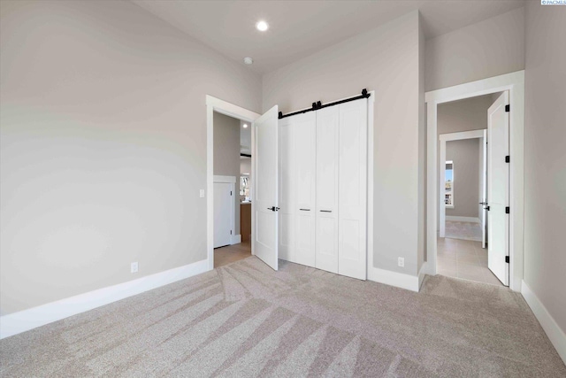 4402 Everett St, West Richland, WA 99353 - unfurnished bedroom featuring a closet, light colored carpet, and a barn door