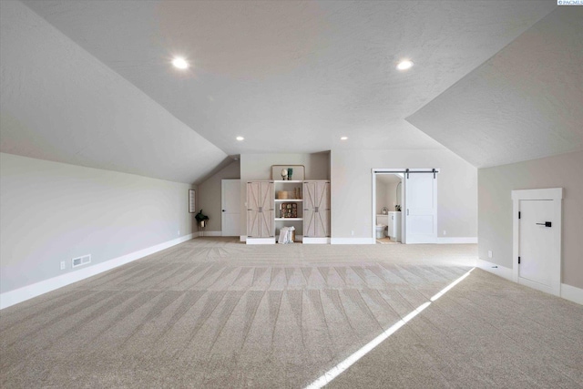 4402 Everett St, West Richland, WA 99353 - additional living space featuring lofted ceiling, a barn door, light carpet, and a textured ceiling