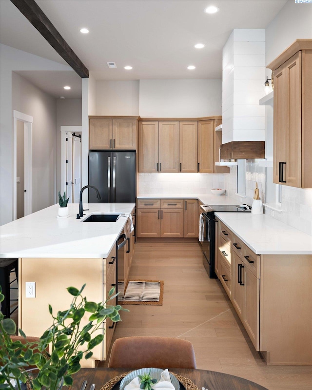 4402 Everett St, West Richland, WA 99353 - kitchen featuring a kitchen island with sink, stainless steel appliances, light brown cabinets, decorative backsplash, and light wood-type flooring