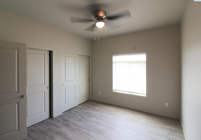 1200 N 8th Ave Unit A204, Othello, WA 99327 - unfurnished bedroom featuring light wood finished floors, a ceiling fan, and two closets