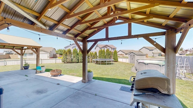 5802 Sidon Ln, Pasco, WA 99301 - fenced backyard featuring a shed, a fire pit, a patio area, a gazebo, and a trampoline