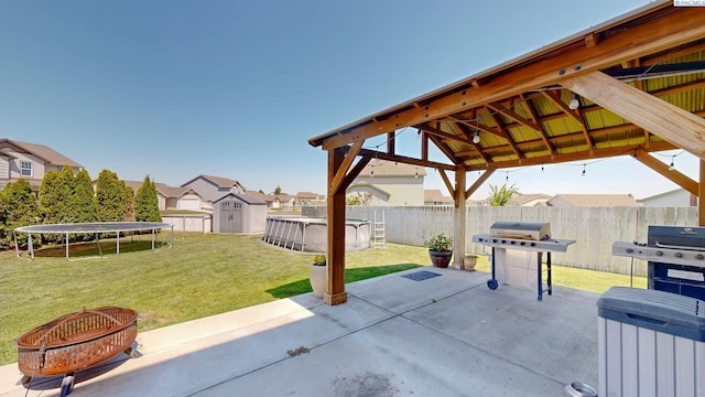 5802 Sidon Ln, Pasco, WA 99301 - view of patio featuring a trampoline, a gazebo, a storage shed, grilling area, and a residential view