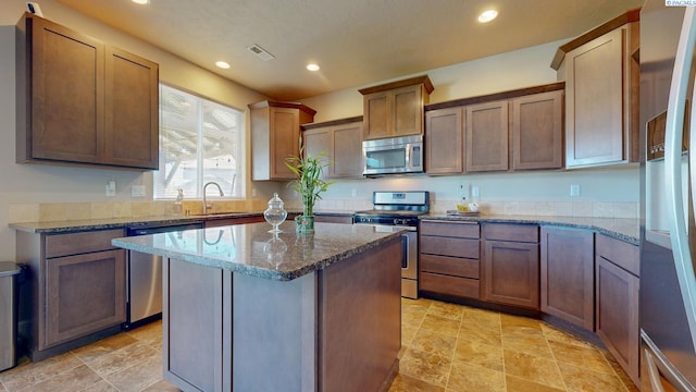 5802 Sidon Ln, Pasco, WA 99301 - kitchen featuring stainless steel appliances, recessed lighting, stone countertops, a center island, and light stone finish floors