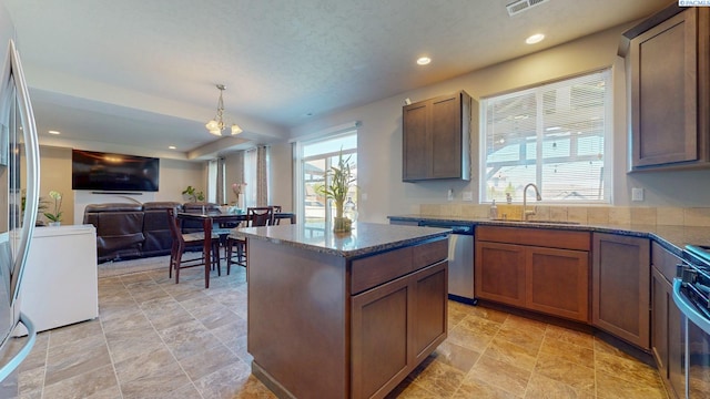 5802 Sidon Ln, Pasco, WA 99301 - kitchen with appliances with stainless steel finishes, open floor plan, dark stone countertops, a kitchen island, and recessed lighting