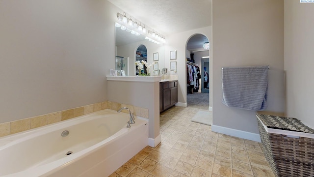 5802 Sidon Ln, Pasco, WA 99301 - bathroom with a walk in closet, vanity, and a garden tub