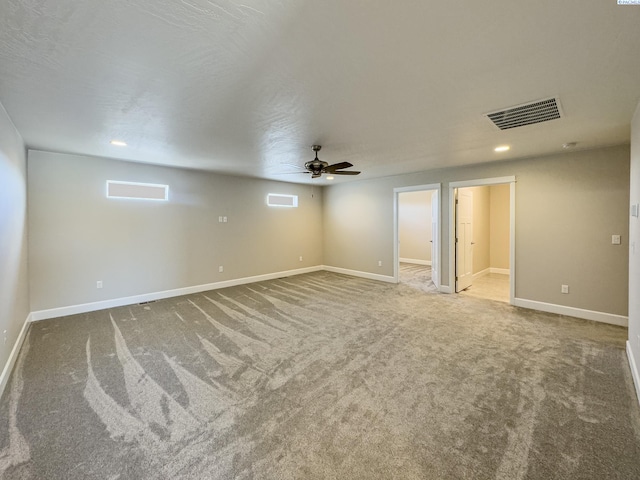 unfurnished room with a ceiling fan, carpet flooring, visible vents, and baseboards