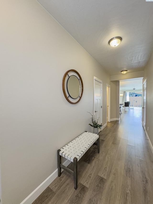 hallway with baseboards and wood finished floors