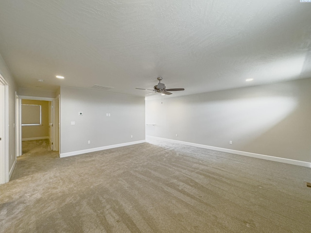 unfurnished room with recessed lighting, light carpet, ceiling fan, a textured ceiling, and baseboards