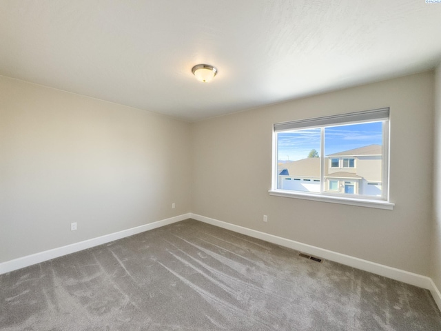 unfurnished room with carpet flooring, visible vents, and baseboards