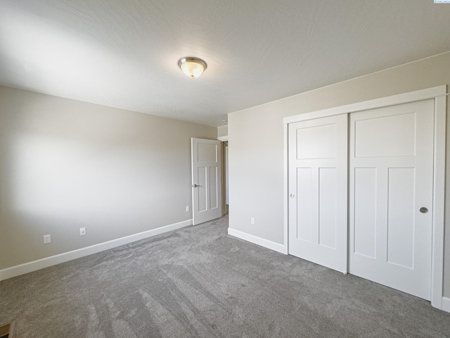 unfurnished bedroom featuring carpet floors, a closet, and baseboards