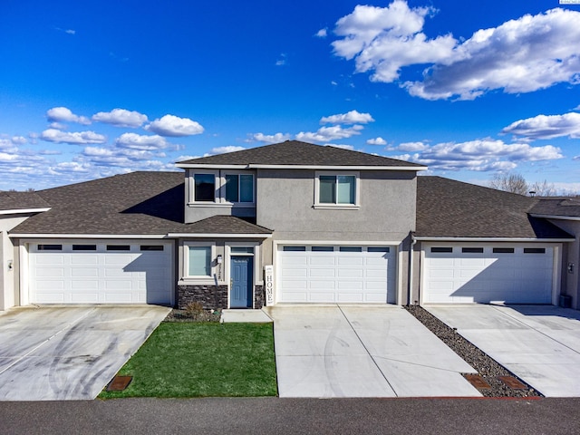 view of front of home with stone siding, roof with shingles, concrete driveway, and stucco siding