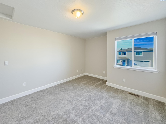 spare room with baseboards, visible vents, and carpet flooring