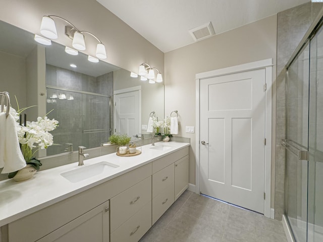 full bath with visible vents, a sink, a shower stall, and double vanity