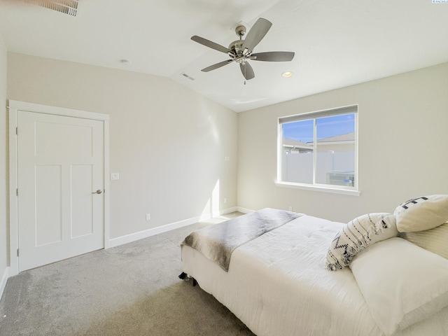 carpeted bedroom with lofted ceiling, baseboards, visible vents, and a ceiling fan