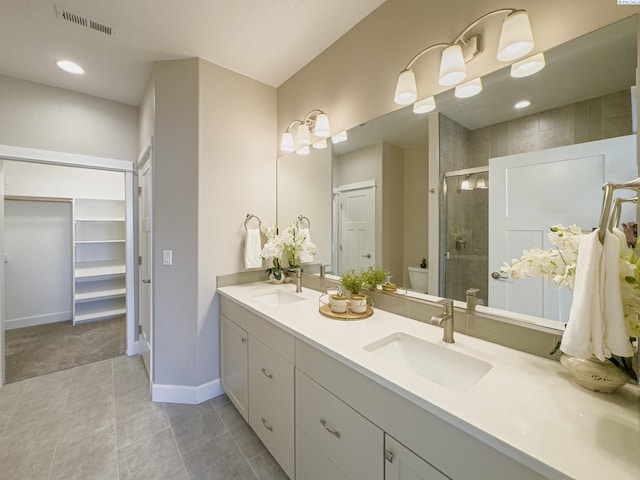 bathroom featuring double vanity, a sink, visible vents, and a shower stall