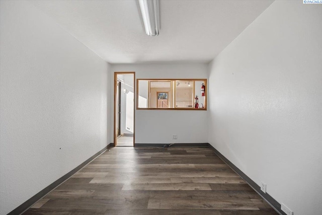 unfurnished room featuring baseboards and wood finished floors