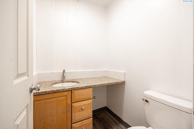 bathroom featuring vanity, toilet, and wood finished floors