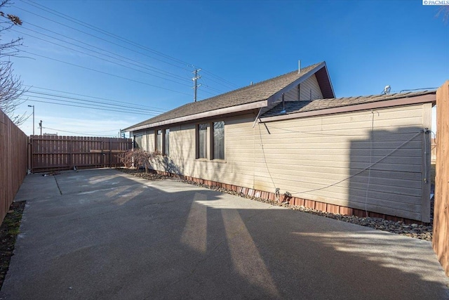 view of side of home with a fenced backyard and a patio