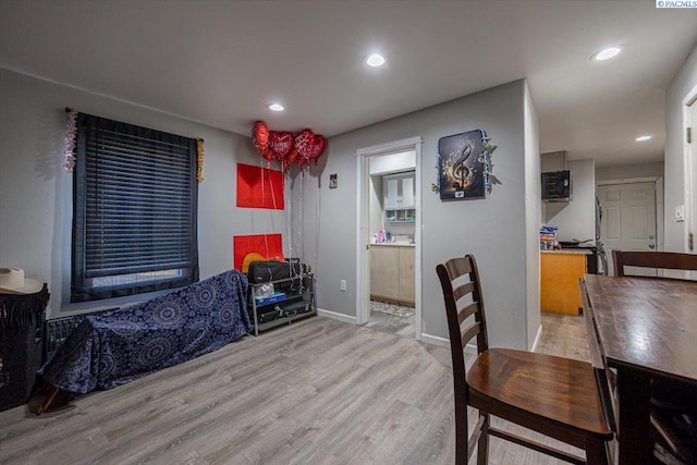 dining space featuring light wood finished floors, baseboards, and recessed lighting