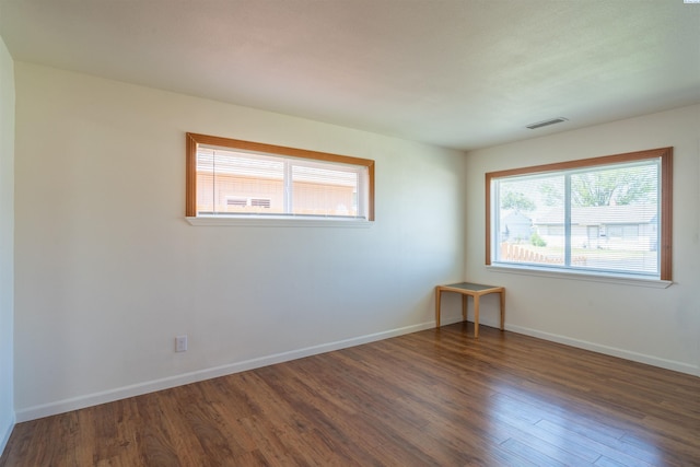 empty room with dark hardwood / wood-style flooring