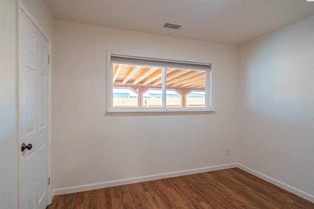 unfurnished room with dark wood-type flooring