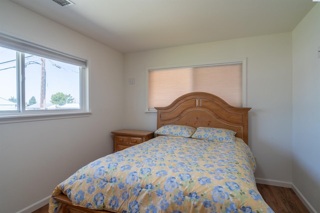 bedroom with dark hardwood / wood-style floors