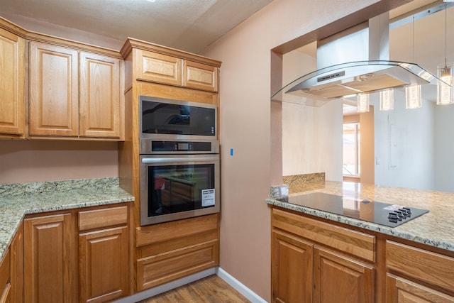 kitchen featuring light stone counters, stainless steel oven, island range hood, black electric stovetop, and light hardwood / wood-style floors