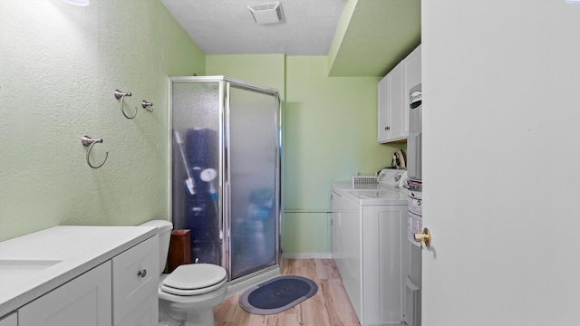 805 W 44th Pl, Kennewick, WA 99337 - full bath with wood finished floors, a stall shower, toilet, vanity, and washing machine and clothes dryer