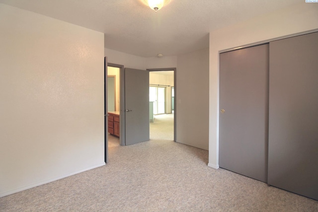 unfurnished bedroom featuring a closet and light colored carpet