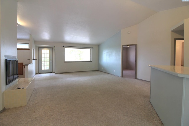 unfurnished living room featuring light carpet and lofted ceiling
