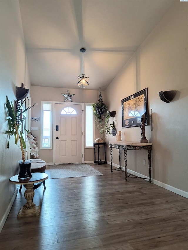 foyer entrance featuring lofted ceiling, baseboards, and wood finished floors