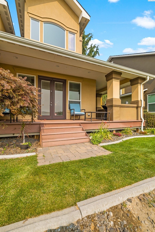 view of exterior entry with french doors and a yard